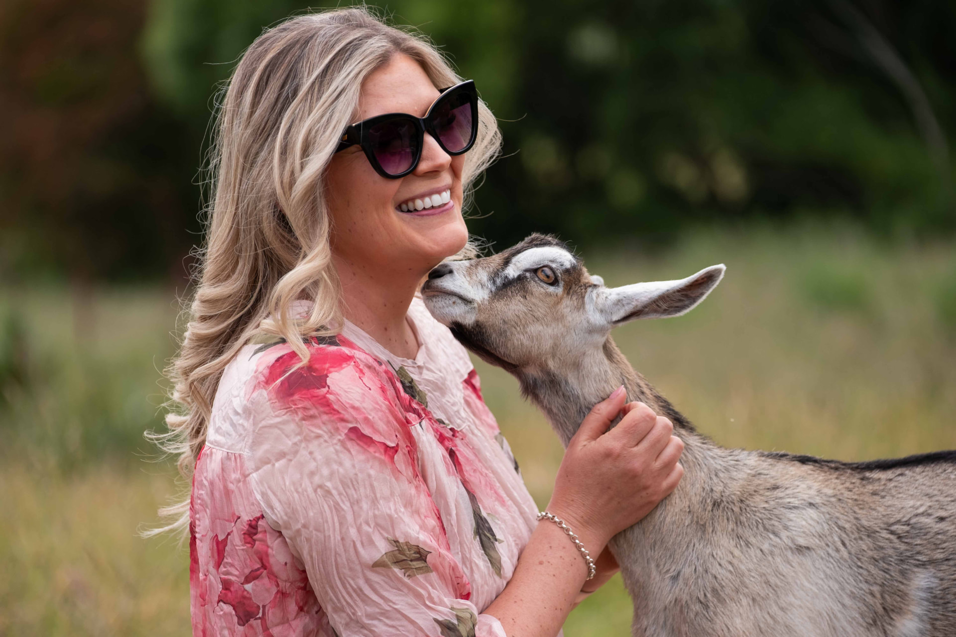 Leese Rogers laughing with a goat between shots